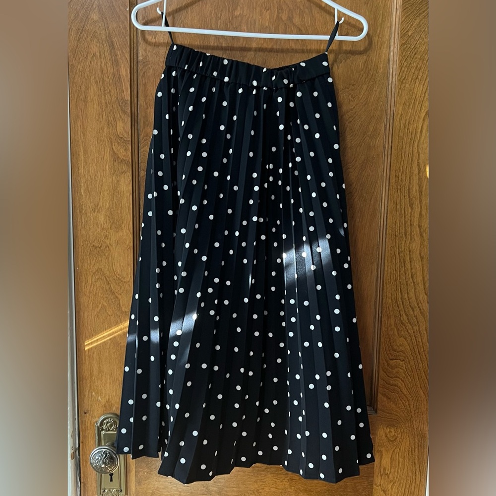 Black pleated tea-length skirt with white polka dots